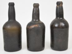 Three green glass wine bottles, each 23.5cm tall.