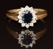 A 9ct gold ring set with an oval cut sapphire of approximately 1.3ct surrounded by diamonds, 3.9g,