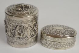 Two Burmese or similar silver pots, one with embossed decoration of deities, height of larger 8cm,