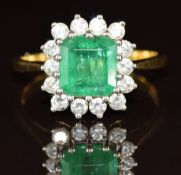 An 18ct gold ring set with an emerald cut emerald of approximately 2ct surrounded by diamonds,