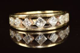 A 14k gold ring set with seven graduating princess cut diamonds, the centre diamond approximately