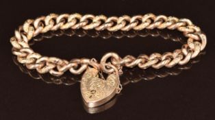 A 9ct gold curb link bracelet with alternating smooth and engraved links and heart padlock clasp,
