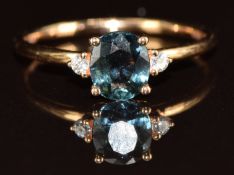 An 18ct gold ring set with a green sapphire of approximately 0.8ct and two diamonds, 1.4g, size J