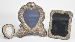 Three hallmarked silver photograph frames comprising two heart shaped examples, the larger London