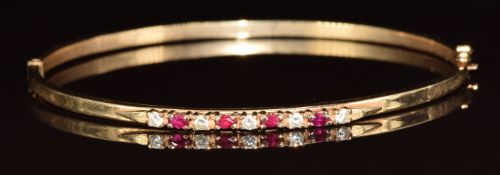 A 9ct gold bangle set with rubies and cubic zirconia, 5.2g, 5.5 x 6cm