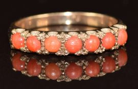 A 9ct gold ring set with seven coral cabochons, 2g, size M