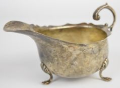 Edward VII hallmarked silver sauce boat with scroll handle, raised on three hoof feet, Birmingham