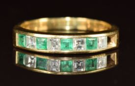 An 18k gold half eternity ring set with alternating square cut emeralds and diamonds, each