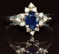 A white metal ring set with an oval cut sapphire of approximately 0.6ct and diamonds, 3.2g, size R/S