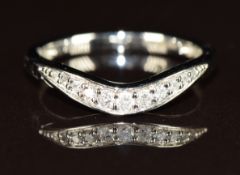 A platinum ring set with eleven diamonds in a curved setting, the total diamond weight approximately