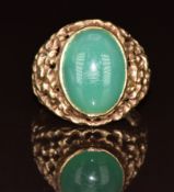 A 9ct gold ring set with green agate cabochon with textured pierced shoulders, 7.3g, size R