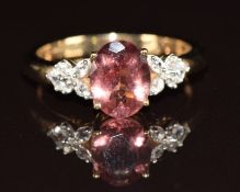 A 9ct gold ring set with an oval cut pink tourmaline and white zircon, 2.9g, size Q