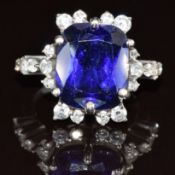 A white metal ring set with a lab grown tanzanite and diamonds, 5.1g, size G