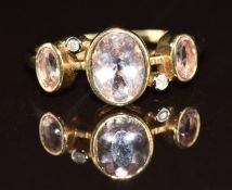 A 9ct gold ring set with three oval cut morganite and diamonds, 2.6g, size P