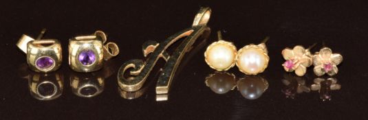 A 9ct gold 'A' pendant and three pairs of 9ct gold earrings set with amethysts, rubies and pearls,