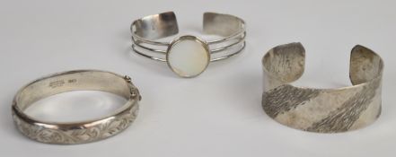 Three silver bangles, one set with mother of pearl, 83g