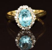 An 18ct gold ring set with an oval cut zircon surrounded by diamonds, 3.6g, size O