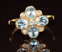 A 9ct gold ring set with aquamarines and a diamond to the centre, 2.6g, size M
