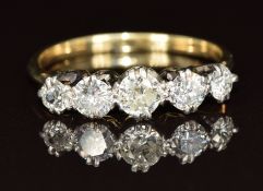 An 18ct gold ring set with five diamonds, the centre diamond approximately 0.2ct, 2.1g, size O