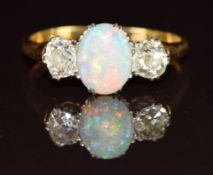 A c1900 18ct gold ring set with an oval opal cabochon and two old cut diamonds each approximately