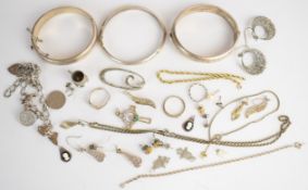 A collection of silver jewellery including three bangles, charm bracelet, two pairs of earrings