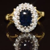 An 18ct gold ring set with an oval cut sapphire of approximately 1.2ct surrounded by diamonds, 4.5g,