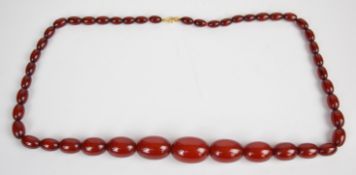 A cherry amber necklace with 9ct gold clasp, the largest bead 19.3 x 28mm, 53g