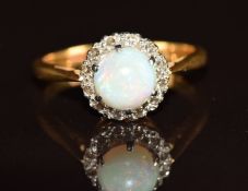 A c1930 18ct gold ring set with an opal cabochon surrounded by diamonds, 3.4g, size L