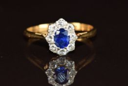 An 18ct gold ring set with an oval cut sapphire of approximately 0.3ct surrounded by diamonds, 2.3g,