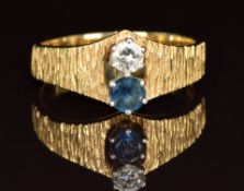 An 18k gold ring set with sapphire and diamond with textured shoulders, 3.7g, size L