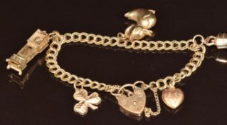 A 9ct gold charm bracelet with five 9ct gold charms comprising heart, shamrock, duck, clock and