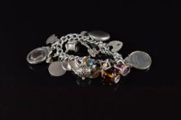A silver charm bracelet with twenty two silver charms including 'Welsh Football League' fob, locket,