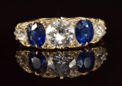 A c1900 18ct gold ring set with a diamond of approximately 1ct, two oval cut sapphires each