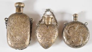 Three hallmarked silver / white metal scent / perfume bottles including a heart shaped example by