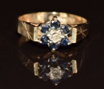 A 9ct gold ring set with a diamond surrounded by sapphires, 2.2g, size M