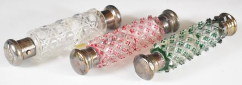 Three hallmarked silver mounted overlaid cut glass, double ended scent bottles, tallest 8.5cm
