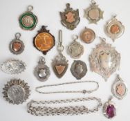 Eleven silver fobs, two Edwardian silver brooches, silver chain, silver pendant, etc