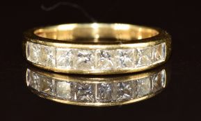 An 18ct gold ring set with eight graduating princess cut diamonds, the centre diamond