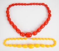 A cherry amber necklace of twenty nine oval beads (32 x 25mm, 113g) and a Baltic amber necklace of