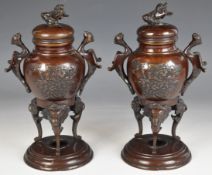Pair of Meiji period Japanese bronze covered censers, with figural bird handles, supported on