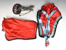 Two Chinese embroidered hats with metal Buddha and bell ornaments, together with an embroidered silk