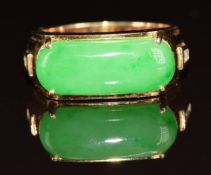 An 18k gold ring set with a jadeite cabochon and two diamonds to each shoulder, 9.5g, size R