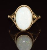 A 9ct gold ring set with an oval opal cabochon, 3.6g, size O