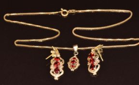 A 9ct gold pendant set with three garnets on 9ct gold chain (40cm) and a pair of matching
