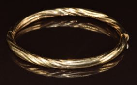 A 9ct gold bangle with textured ripple finish, 12.4g, 6.2 x 5.2cm