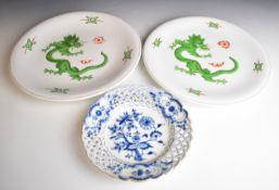 Pair of Meissen chargers with dragon decoration and a Meissen plate with reticulated border, largest