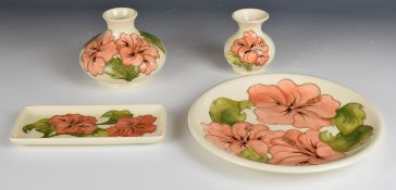 Moorcroft two pedestal vases, pen tray and charger all decorated in the Hibiscus pattern, tallest