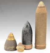 Four pieces of WW1 inert ordnance comprising solid shot, two fuse cones and a shell with fuse,