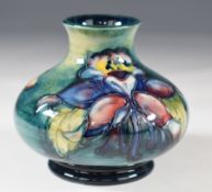 Moorcroft squat pedestal vase decorated in the Spring Flowers / Orchid pattern, with Queen Mary