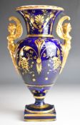 Coalport 19thC pedestal vase with figural twin handles, decorated with seated figures embroidering /